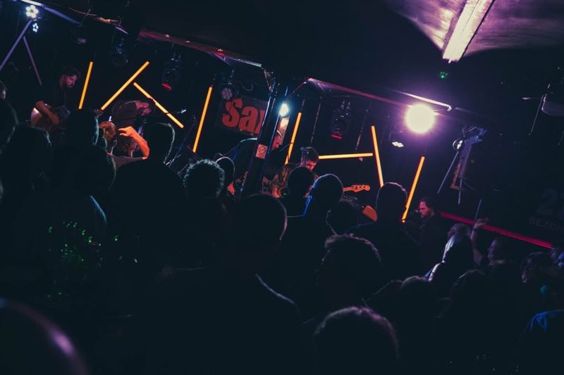 The Sax! club stage in orange light during a concert